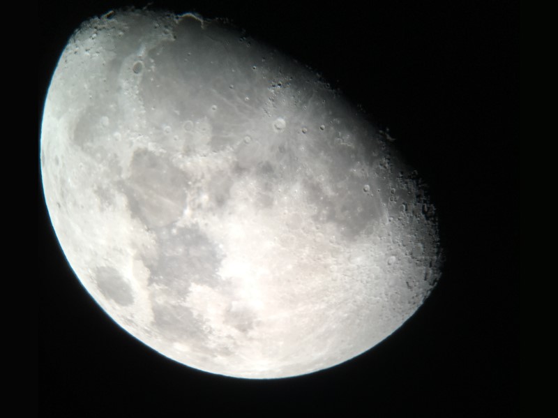 Image de la Lune prise avec un télescope moderne et la caméra d'un
    téléphone. On voit des ombres faites par les montagnes.